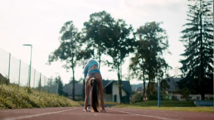 SLO MO运动年轻女子在跑道上练习倒立