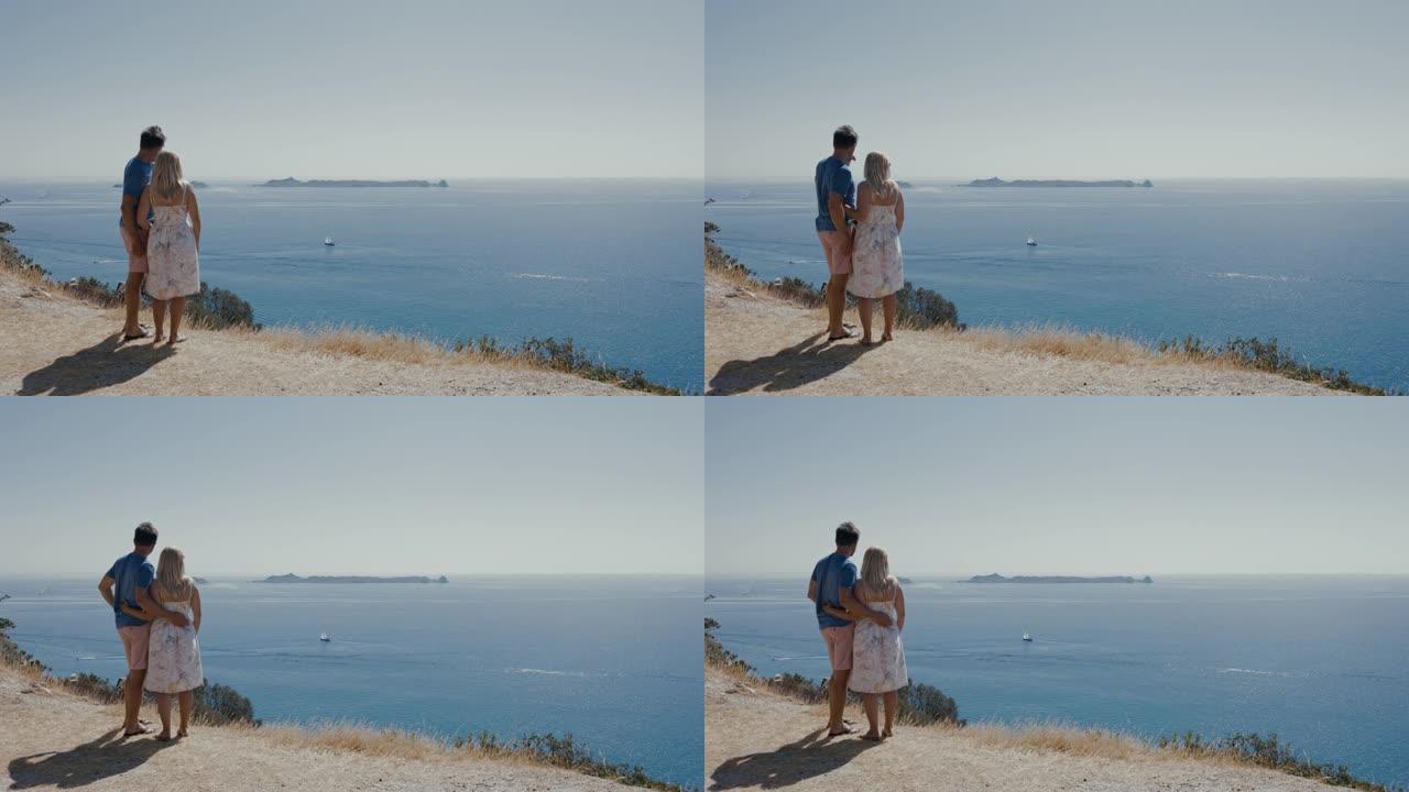 意大利撒丁岛，一对夫妇从悬崖上眺望大海。