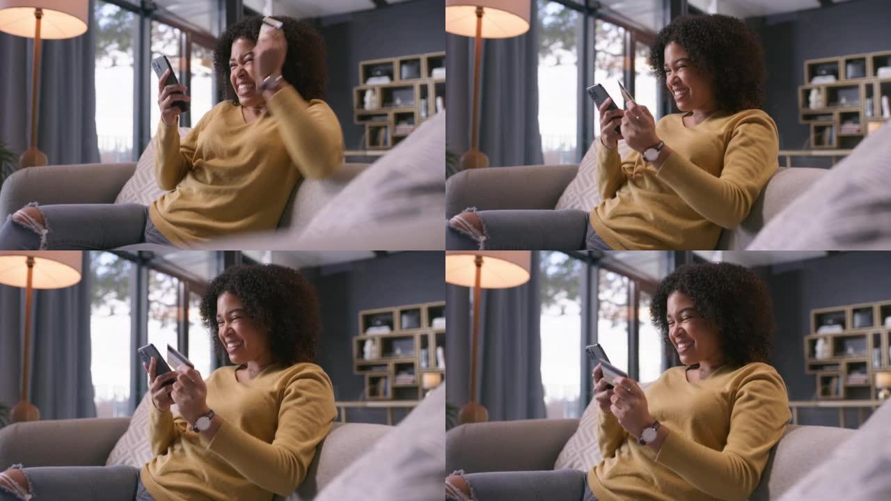 4k视频片段，一名年轻女子使用带有信用卡的智能手机并在家中沙发上欢呼