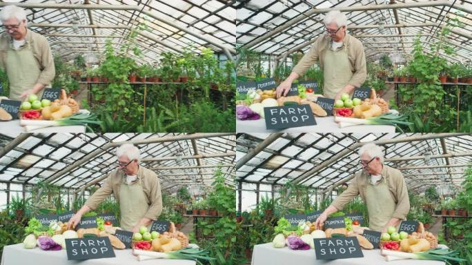 在温室中出售新鲜农产品的高级男性农民