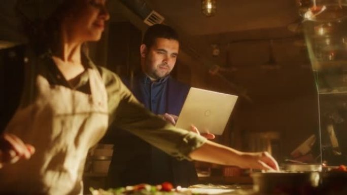 在餐馆小企业主: 男性和女性的商业伙伴使用笔记本电脑。正宗披萨店烹饪美味的有机生态食品。两名企业家在
