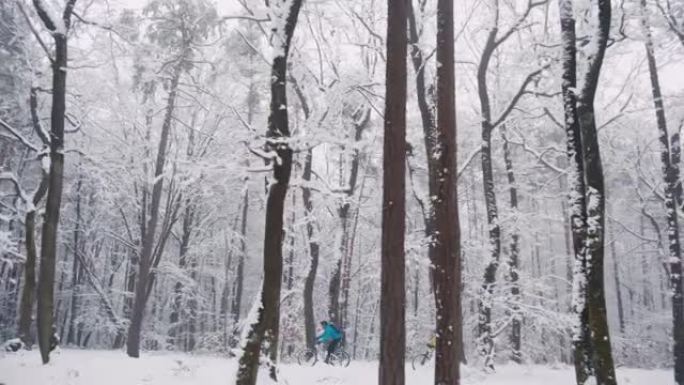 两名骑自行车的人骑着自行车穿越冰雪覆盖的森林。