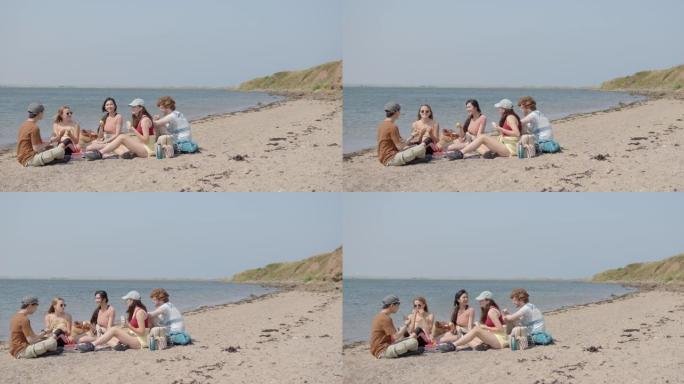 朋友在海滩吃盒饭外国人年轻人团体