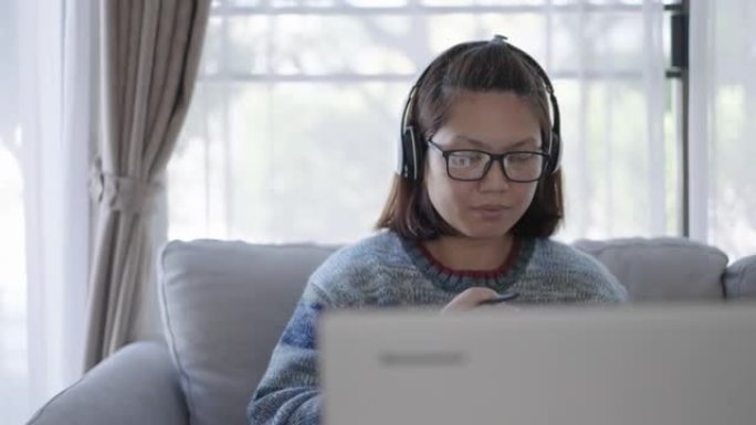 成熟的女人在家用笔记本电脑工作