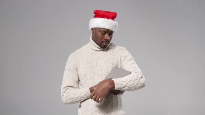 一个戴着圣诞帽和羊毛针织毛衣的黑皮肤男人
