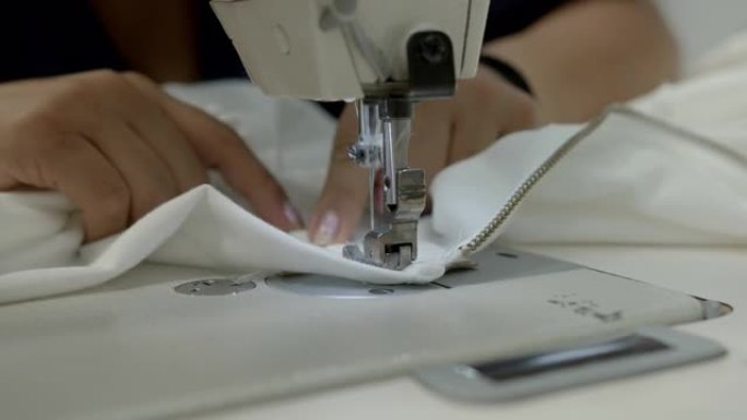 无法辨认的女人在纺织厂缝制衬衫的特写