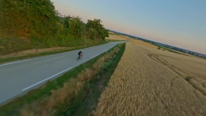 空中专业自行车手在日落时分骑自行车穿越乡村