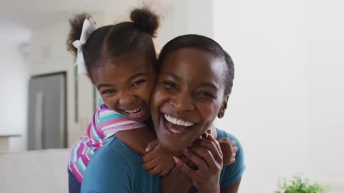 快乐的非洲裔美国母亲和女儿在家中拥抱的肖像
