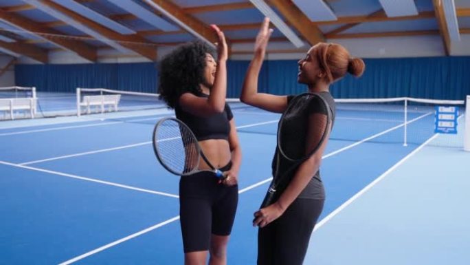 两名非洲网球运动员站在室内球场上