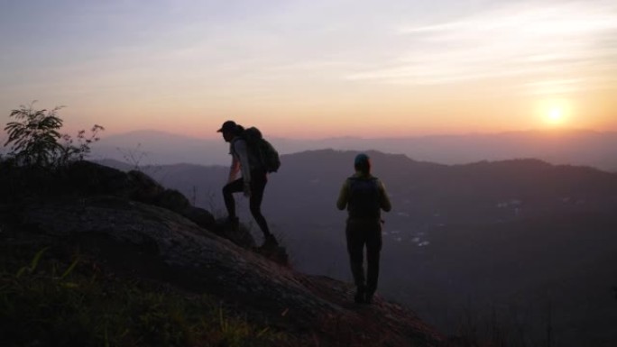 两名徒步旅行者在远足小径上帮助登顶山顶