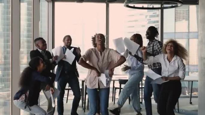 非洲族裔公司员工在办公室跳舞庆祝合作成功