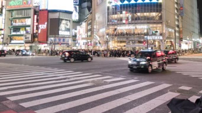涩谷与许多行人和车辆在日本东京夜间穿越路口