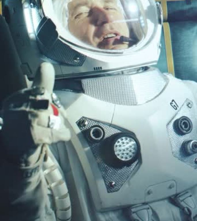 在轨道上的太空船上快乐的宇航员的肖像。穿着未来派西装的宇航员充满了欢乐，并在视频通话中挥舞着手。来自