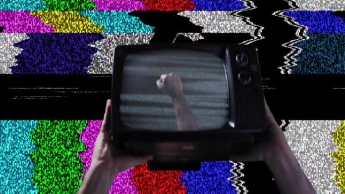 紧握的拳头在复古电视和彩色条作为背景。特写镜头。