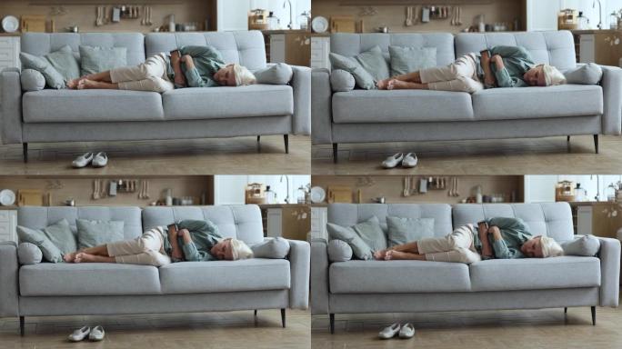 疲惫的女人躺在沙发上感到恶心或沮丧
