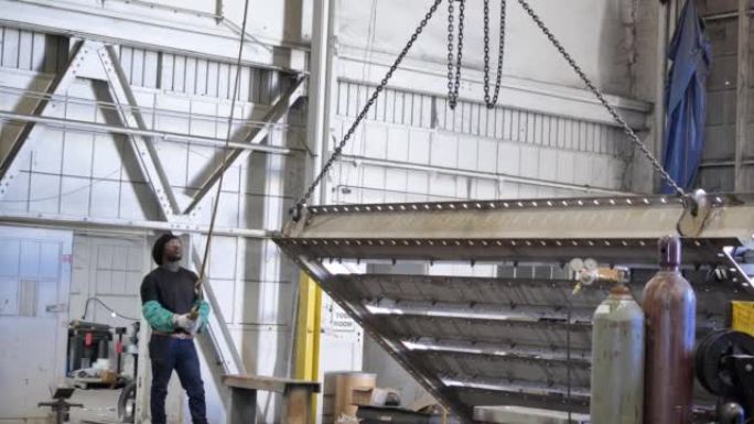 工厂中的非裔美国人用滑轮抬起物体