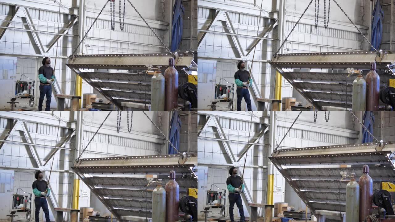 工厂中的非裔美国人用滑轮抬起物体