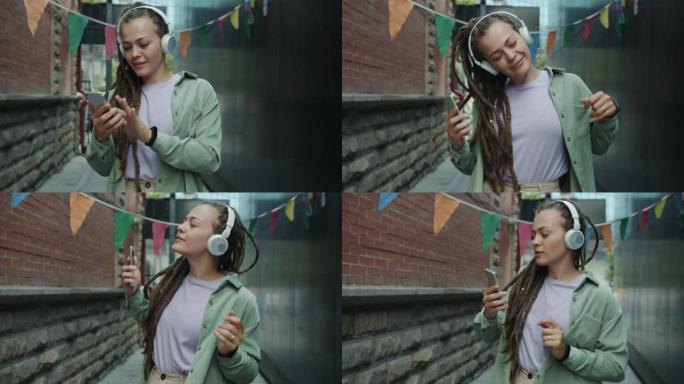朋克女孩戴着无线耳机在城市街道上跳舞，玩得开心