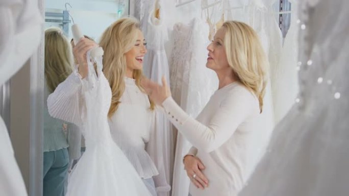 母亲在新娘商店帮助成年女儿选择婚纱-慢动作拍摄