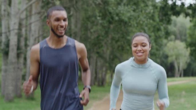 两个健康的人在公园里跑步，享受他们的日常锻炼和户外健身。自信微笑的女性慢跑和快乐的非洲男性在大自然风