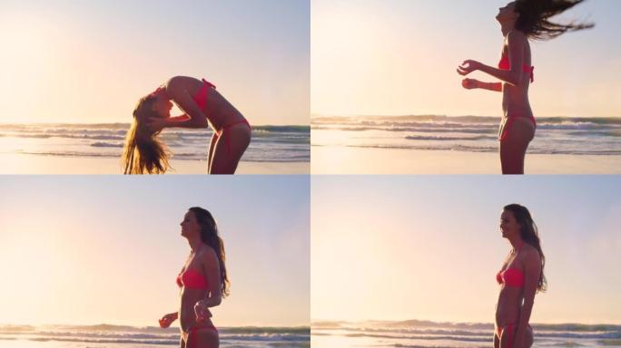 4k视频片段，一个迷人的年轻女子独自站在海滩上，在日落时玩弄头发