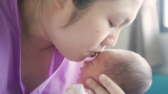 母亲抱着儿子，在分娩后在医院用爱心亲吻新生儿