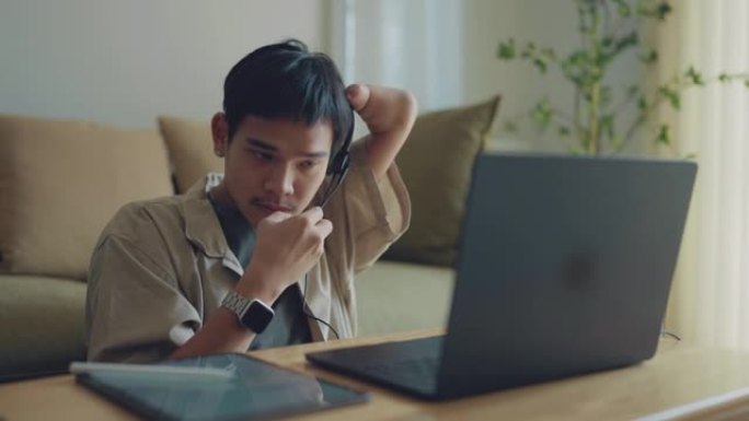 亚洲男子残疾畸形的手臂在家里工作。