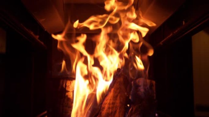 特写镜头，dop: 在黑暗的客厅里燃烧的舒适大火的电影镜头。