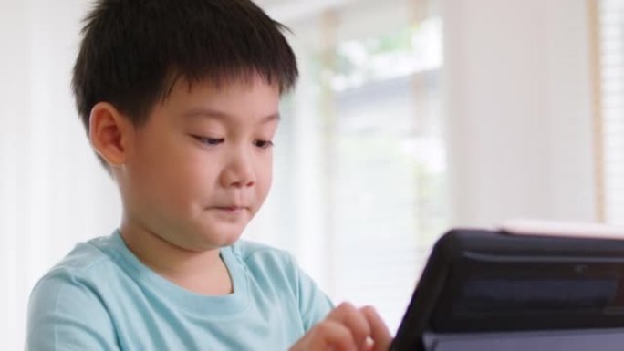 孩子享受周末活动在家数字平板电脑上在线玩游戏。