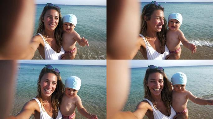 真实的快乐无忧无虑微笑的新妈妈和她的新生婴儿在海滩上给父亲或亲戚自拍或视频通话的照片