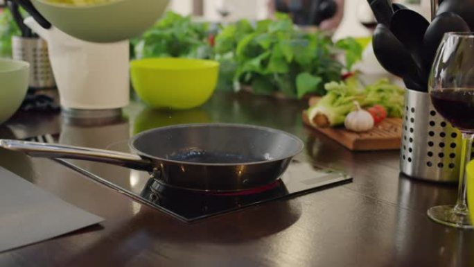 厨师在煎锅中倒油和在厨房烹饪蔬菜的特写镜头