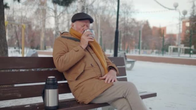 老人在长凳上喝茶外国男人老年人喝水人文生