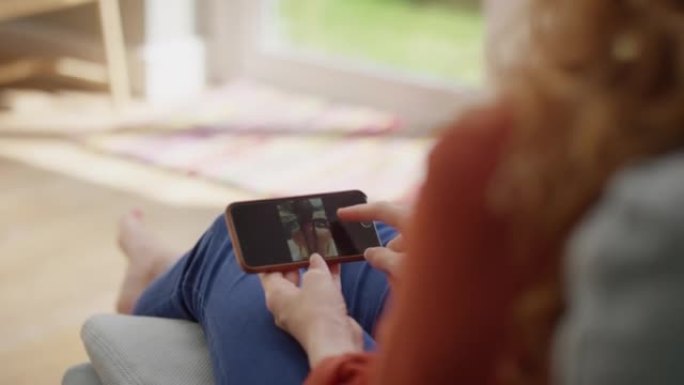 4k视频片段，一名妇女在智能手机上浏览照片
