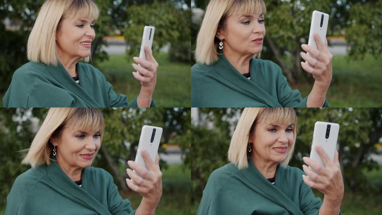 快乐的社交女士在户外使用智能手机进行在线交流的视频通话中聊天