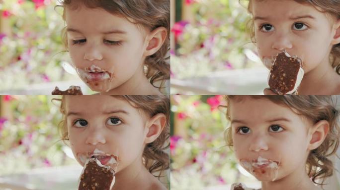 可爱的蹒跚学步的女孩吃冰淇淋蛋卷。