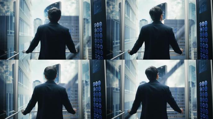时尚的日本商人骑玻璃电梯到现代商务中心的办公室。男性在电梯的全景窗口外看着现代的市中心摩天大楼。回到