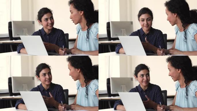 多种族女性同事在项目中使用笔记本电脑一起工作