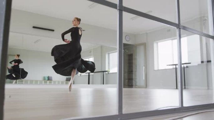 高加索女芭蕾舞演员在明亮的工作室的舞蹈课上练习芭蕾舞