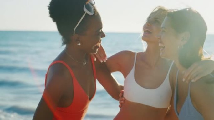 穿着比基尼的年轻多民族女友在日落时分有大海的海滩上一起享受暑假。