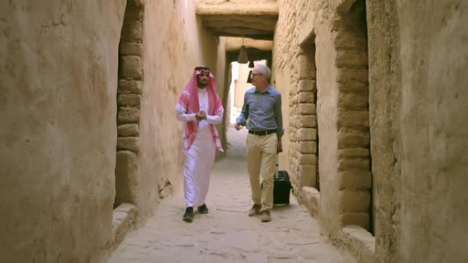 来访的商人与沙特当地人散步交谈