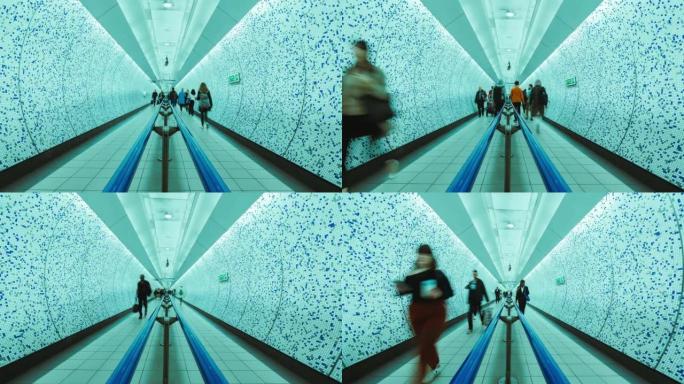 伦敦地下换乘站之间的隧道人行道上拥挤的通勤者的时间流逝