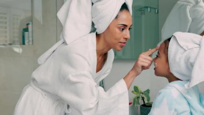 妈妈、面霜和女孩在浴室用美容产品化妆品护肤露晨间自我护理常规。快乐的母亲，微笑的孩子和孩子的爱结合在