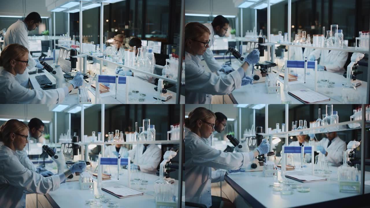 医学研究科学家团队在显微镜，试管，微量移液器和台式计算机的帮助下进行实验。现代生物应用科学实验室，拥
