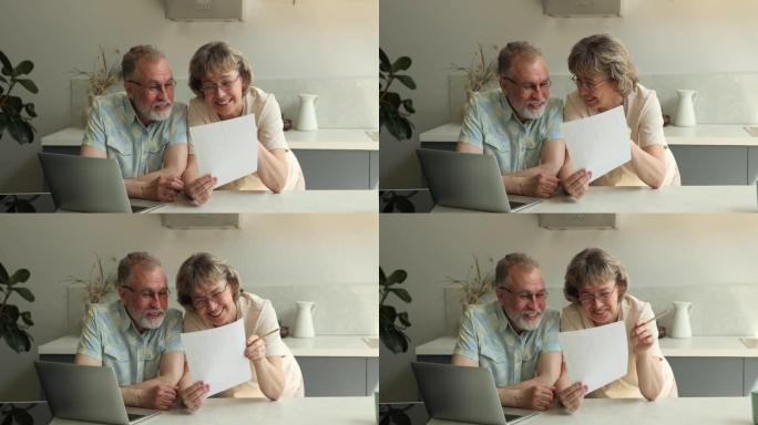 微笑的老年夫妇支票打印的银行储蓄对账单感到满意