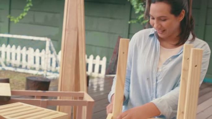 4k视频片段，一名年轻女子与她可爱的儿子在家中从事木制项目