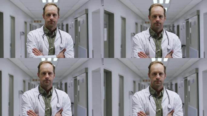 站在医院走廊上双臂交叉的白人男性医生的肖像
