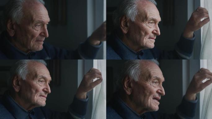 早上，一位体贴入微的面带微笑的老人的电影特写镜头正看着窗外。生活概念，养老金领取者，祖父母，退休，寄