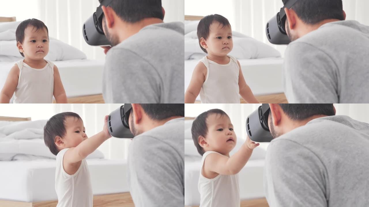 亚洲父亲戴着虚拟现实耳机，看着未来的东西周围的互动技术与儿子年龄10个月的好奇心，同时呆在家里，以防