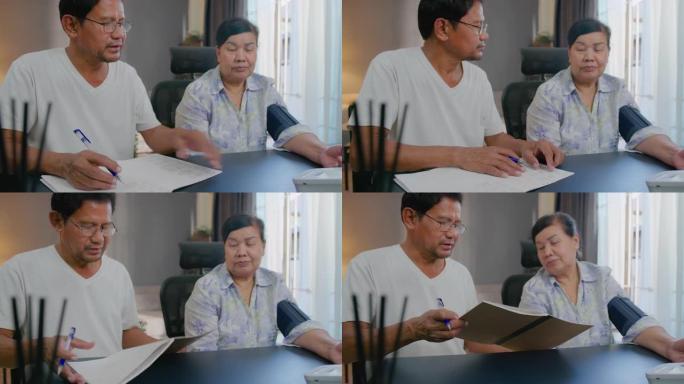 亚洲资深男子在家笔记本上写血压和心率的数字