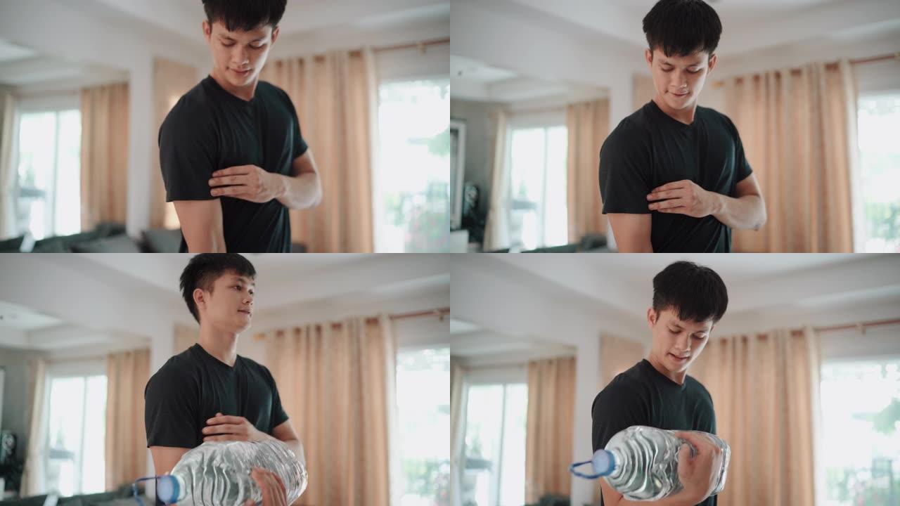 亚洲男子在家中使用塑料加仑水瓶代替健身房举重锻炼手臂二头肌